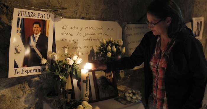 Una salvadoreña enciende una vela a las afueras del hospital donde falleció el ex presidente salvadoreño Francisco Flores. Foto: EFE.