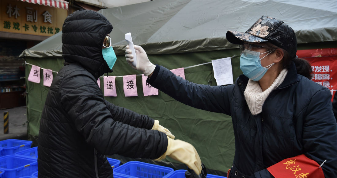 Una Mujer Revisa La Temperatura a Un Ciclista Que Porta Una Mascarilla En La Ciudad De Wuhan En El Centro De China El Viernes De Febrero De Foto Chinatopix Vía Ap