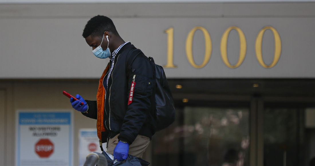 Protegiéndose del coronavirus, una persona camina frente a un hospital en la ciudad de Nueva York el 26 de marzo del 2020. Foto: John Minchillo, AP