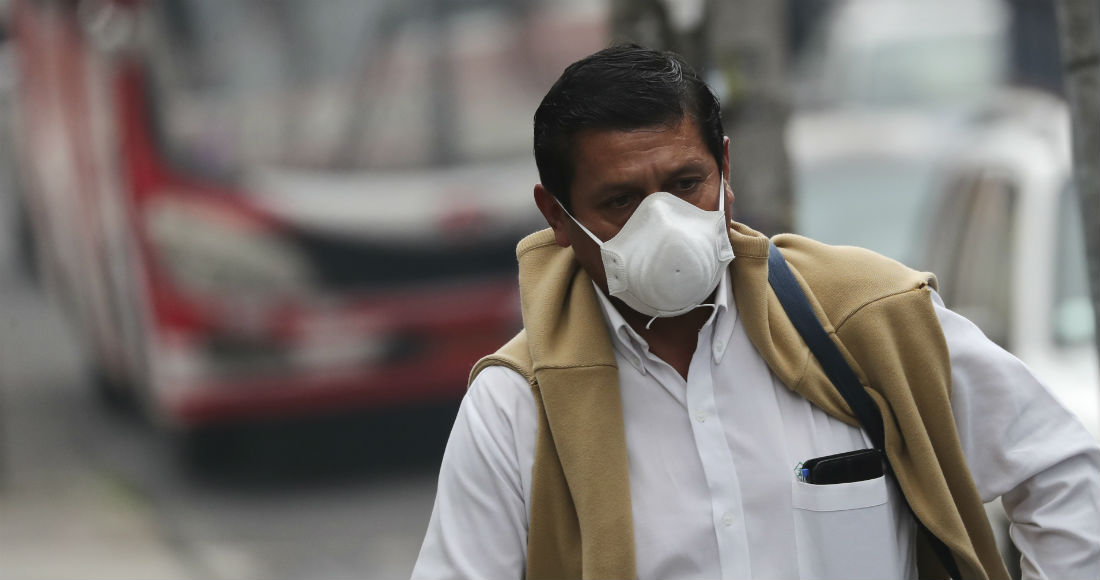 Un hombre usa una mascarilla mientras camina por una calle de Quito, Ecuador, el jueves 12 de marzo de 2020. Foto: Dolores Ochoa, AP