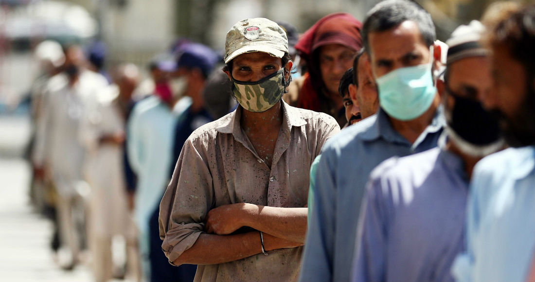 Decenas de personas protegidas con mascarillas esperan su tuno para recibir comida en Karachi, Pakistán. Foto: EFE/EPA/SHAHZAIB AKBER