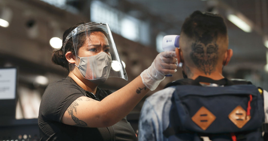 Una empleada con protección contra el nuevo coronavirus toma la temperatura a un cliente a la entrada de una tienda en Ciudad de México el martes 30 de junio de 2020.