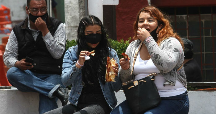 Mujeres comen comida chatarra.