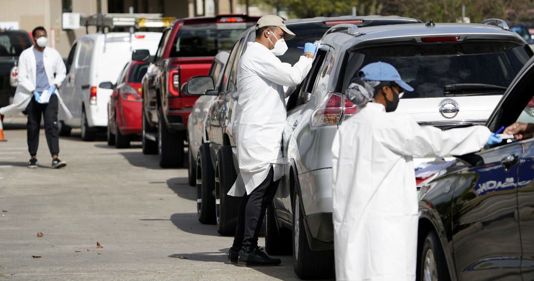 Trabajadores de salud revisan a unas personas que esperan en sus vehículos en el sitio de pruebas de COVID-19 del Centro Médico United Memorial, en Houston, Texas, el jueves 19 de noviembre de 2020.