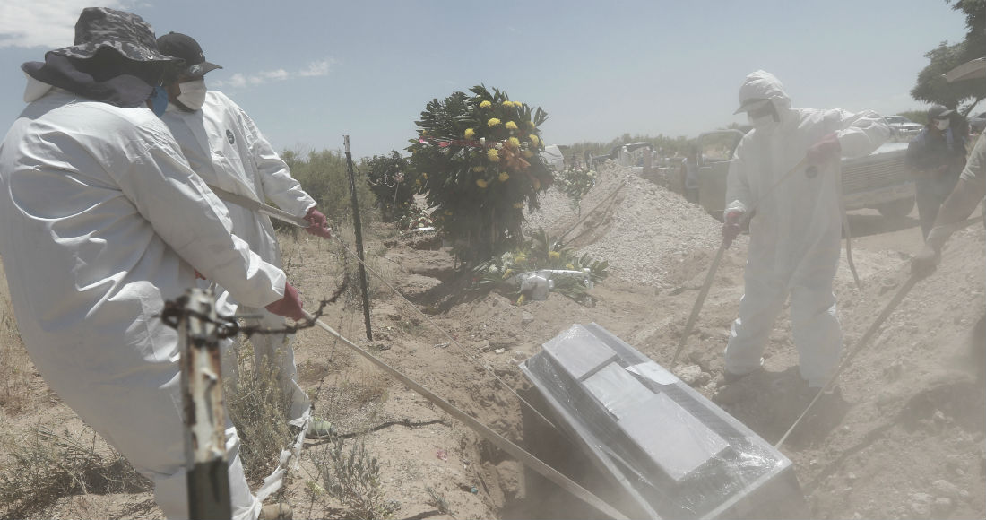 Unos trabajadores portan equipo de protección mientras entierran el martes 19 de mayo de 2020 un ataúd en una zona del cementerio municipal de San Rafael, destinada para los casos de COVID-19 en Ciudad Juárez, México.