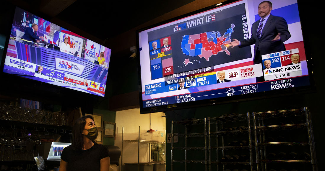 La mesera Sam Schilke sigue los resultados de las elecciones presidenciales de Estados Unidos en un televisor en un bar, el 3 de noviembre de 2020, en Portland, Oregon.