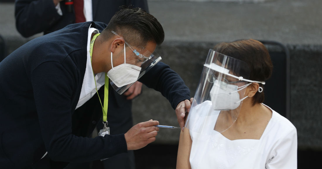 La trabajadora de salud María Ramírez es la primera en vacunarse contra la COVID-19 en el Hospital General de la Ciudad de México, el jueves 24 de diciembre de 2020 en la madrugada. Los primeros lotes de vacunas producidas por Pfizer y su socio alemán, BioNTech llegaron el día anterior.