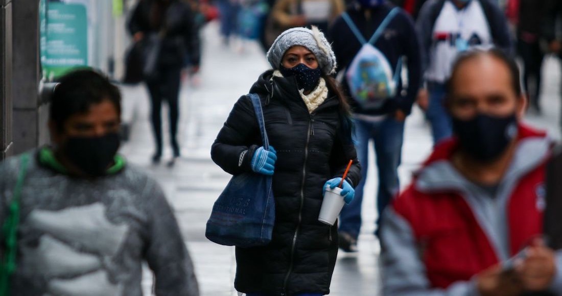 Personas con cubrebocas, chamarras y guantes transitan por el primer cuadro de la Ciudad de México