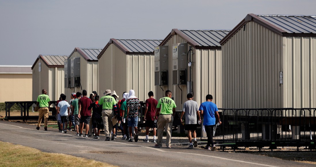 En esta fotografía del 9 de julio de 2019, unos miembros del personal escoltan a unos menores a una clase en un centro de detención para niños migrantes del Gobierno de Estados Unidos en Carrizo Springs, Texas.