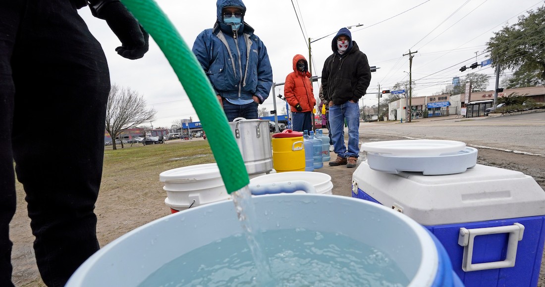 Se llena un barril de agua mientras otros esperan en temperaturas bajo cero para usar una manguera en el grifo de un parque en Houston, 18 de febrero de 2021.