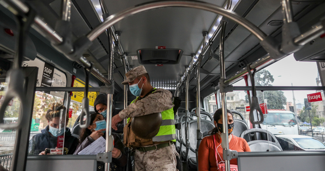 Un soldado verifica permisos de movilidad en un bus de pasajeros en Santiago, Chile, el jueves 25 de marzo de 2021.