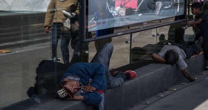 Dos hombres toman un descanso al exterior de la estación San Lázaro del Metrobús.