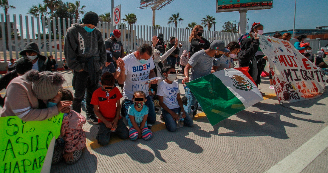 Migrantes rezan en las inmediaciones del cruce fronterizo de El Chaparral, en Tijuana (México).