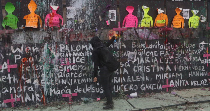 Una mujer lanza fuego con un spray a las policías que resguardan el Palacio Nacional durante la protesta por el Día Internacional de la Mujer.