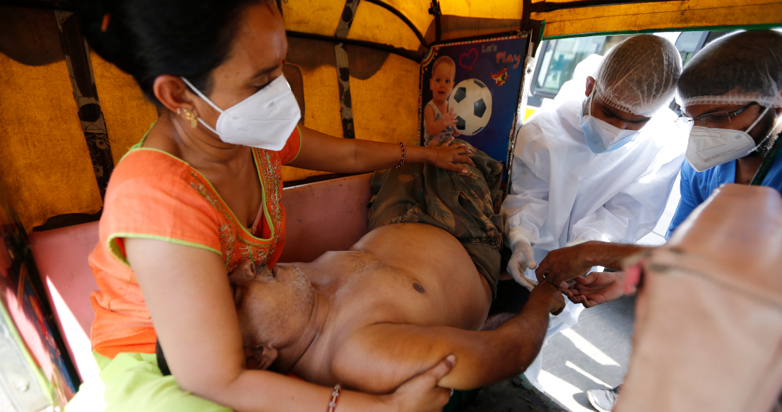 Un paciente con COVID-19 es asistido dentro de un vehículo en un hospital estatal dedicado al tratamiento de la pandemia en Ahmedabad, India, el jueves, 22 de abril del 2021.