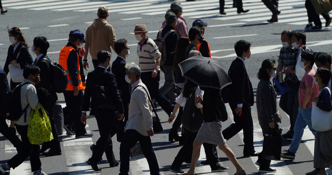 Varias personas, con mascarilla para protegerse del coronavirus, cruzan un paso de peatones en Tokio, El 21 de abril de 2021.