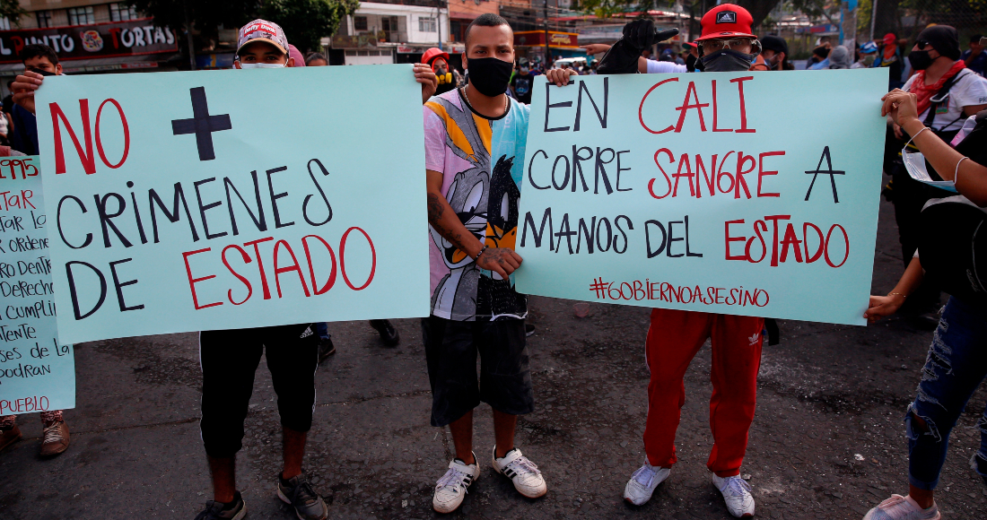 Varias personas sostienen carteles durante unas protestas el 11 de mayo de 2021 en el barrio Siloé, en Cali (Colombia).