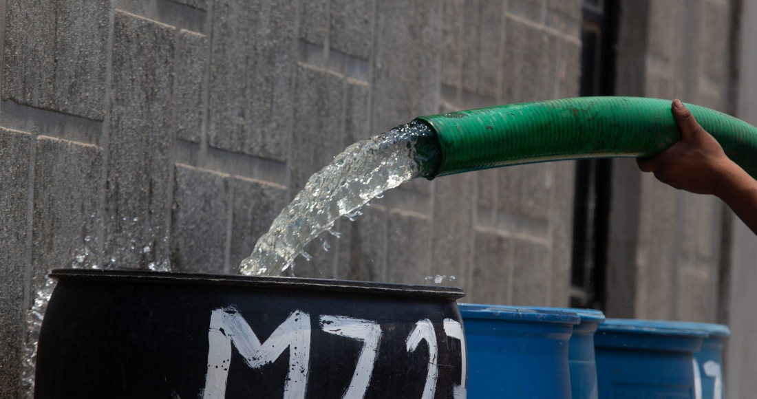 Un trabajador de una pipa de agua abasteció los tambos del vital líquido en la colonia Rubén Jaramillo, ubicada en la Alcaldía Iztapalapa de la Ciudad de México.