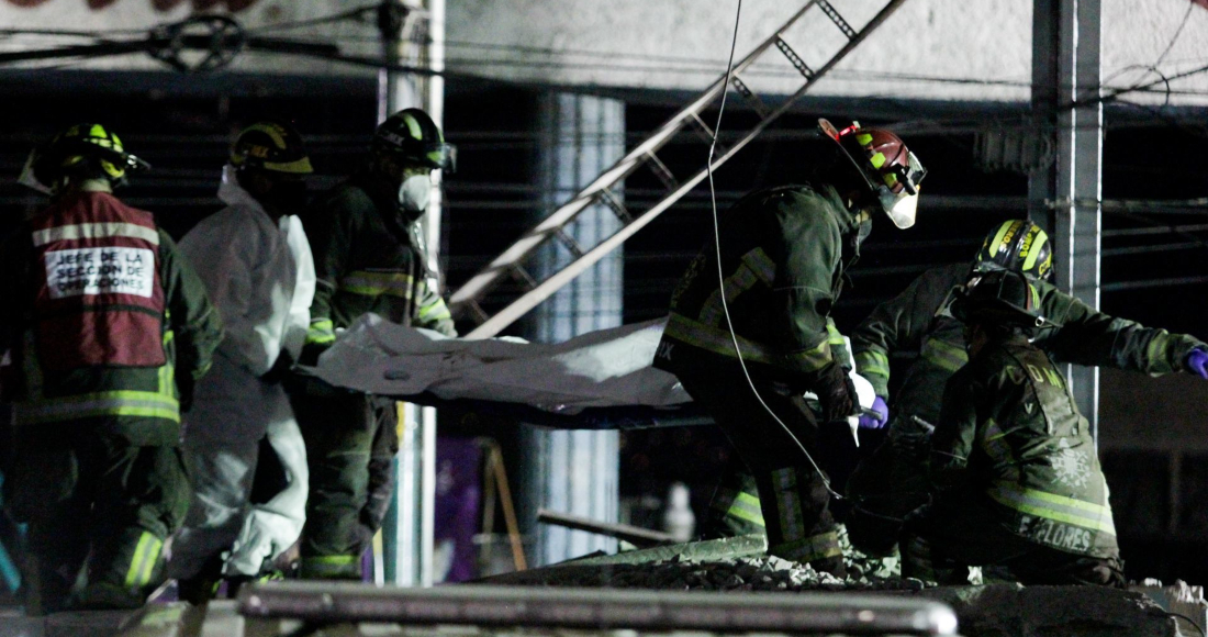 Bomberos trasladan el cuerpo de una víctima del derrumbe de una estructura del Metro de la Ciudad de México, ocurrida en la Línea 12.