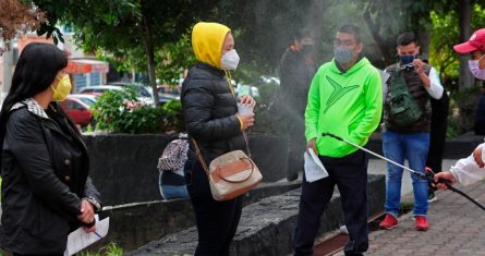 Grupos de jóvenes hacen fila mientras son desinfectados en un modulo de pruebas para detectar la COVID-19, el 15 de julio de 2021, en la Ciudad de México (México).