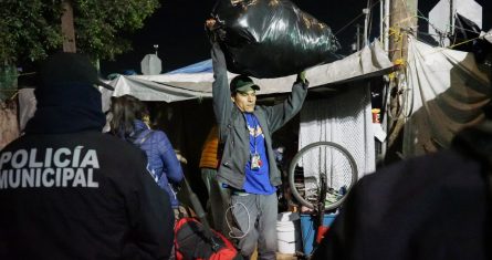 Migrantes retiran sus pertenencias del albergue "El Chaparral" hoy, en Tijuana (México).