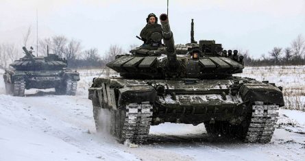 En esta foto distribuida por el Servicio de Prensa del Ministerio de Defensa ruso el 14 de febrero de 2022, tanques recorren un campo durante maniobras militares en la región de Leningrado, Rusia.