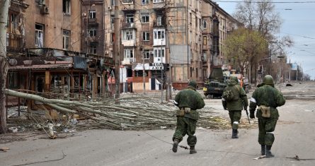 Militares de la milicia de la República Popular de Donetsk caminan entre edificios dañados de apartamentos cerca de la Planta Metalúrgica Ilich de Acero y Hierro, la segunda instalación metalúrgica más grande de Ucrania, en una zona controlada por separatistas con apoyo ruso en Mariúpol, Ucrania, el sábado 16 de abril de 2022.