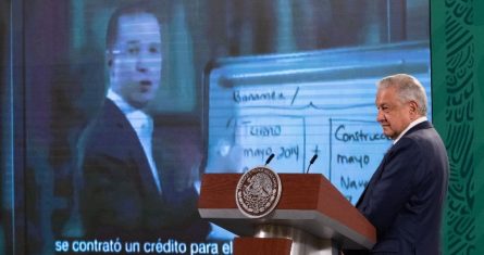 El Presidente Andrés Manuel López Obrador con un video de Ricardo Anaya de fondo.