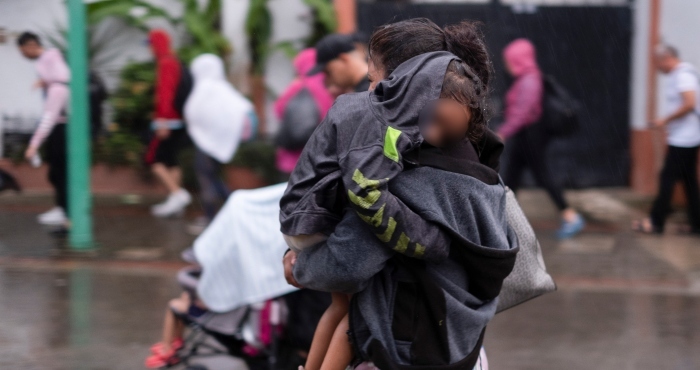 Un Migrante Cargando a Un Niño Camina Bajo Una Lluvia Ligera Con Un Grupo De Migrantes Cuando Salen De La Ciudad De Tapachula En El Estado De Chiapas México La Madrugada Del Lunes De Junio De