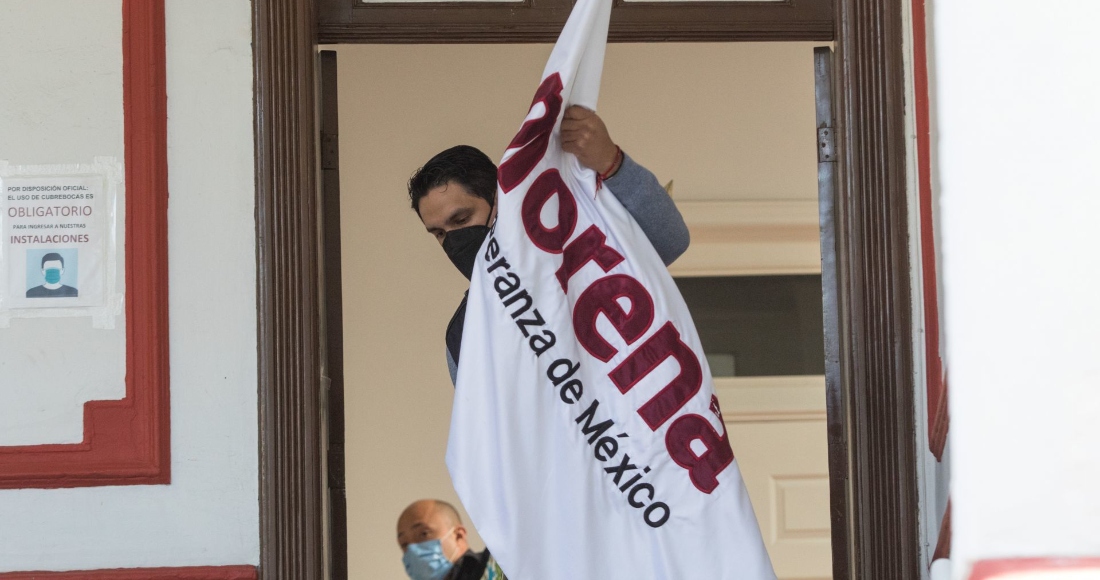 Un Hombre Acomoda Una Bandera De Morena Durante El Anuncio De Coalición Entre El Partido En El Poder Y Nueva Alianza Para El Proceso Electoral