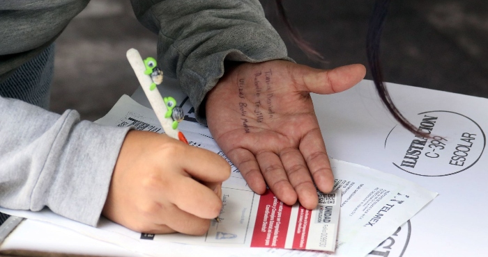 Una Joven Sin Identificar Copia Los Nombres Escritos En Su Mano De Tania Rebollo Contralora De Obras Públicas Del Gobierno De Morelos Y De Ulises Bravo Molina Medio Hermano Del Gobernador En Las Papeletas De Elección De Consejeros Estatales Durante El Proceso Electivo Interno De Morena