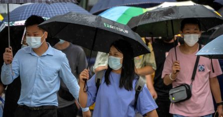 Personas con cubrebocas caminan por una calle del distrito comercial de Beijing, el 9 de agosto de 2022.