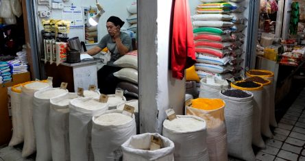 Una vendedora espera a los clientes en su puesto de arroz y otros granos en un mercado en Yakarta, Indonesia, el domingo 14 de agosto de 2022.